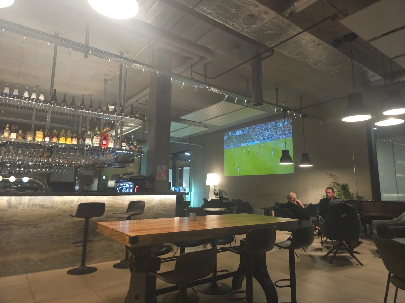 Le grand écran et les tables du bar